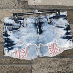 Acid wash shorty shorts with tribal pocket.